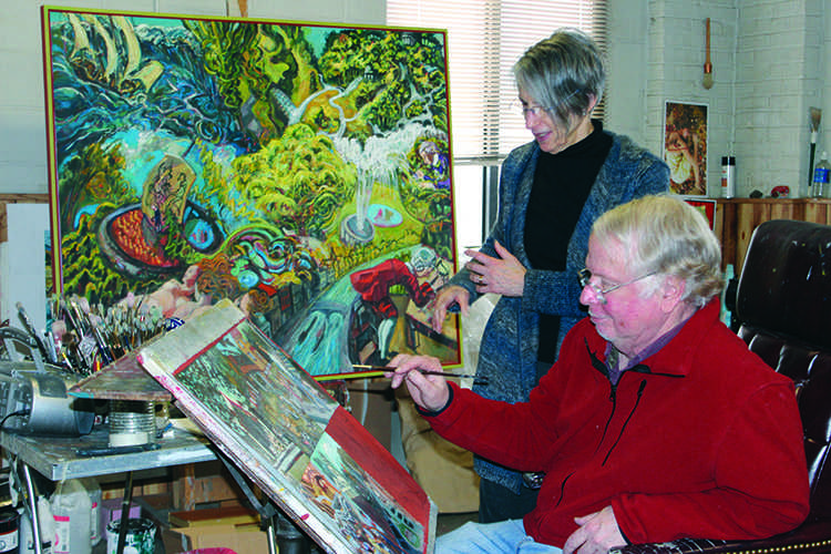 Barbara Shafer looks over husband Andy Shafers shoulder as he works on a new painting. © 2014 Katie Bast. 