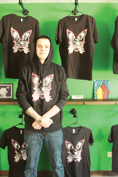 Johnson stands with merchandise at his skate shop’s soon-to-open Dewey Street location. © 2014 Elizabeth Jackson