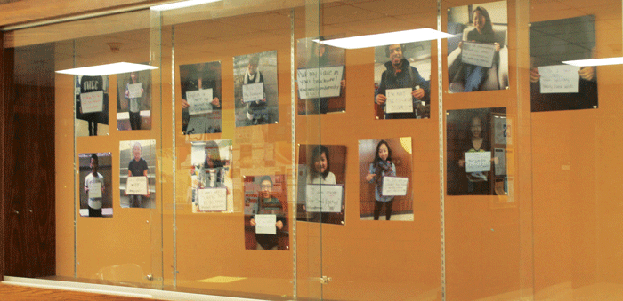 RAISING AWARENESS: The display case on the first floor of Hibbard Humanities Hall shows students of Hmong heritage with signs refuting racial stereotypes. © 2014 Elizabeth Jackson, The Spectator