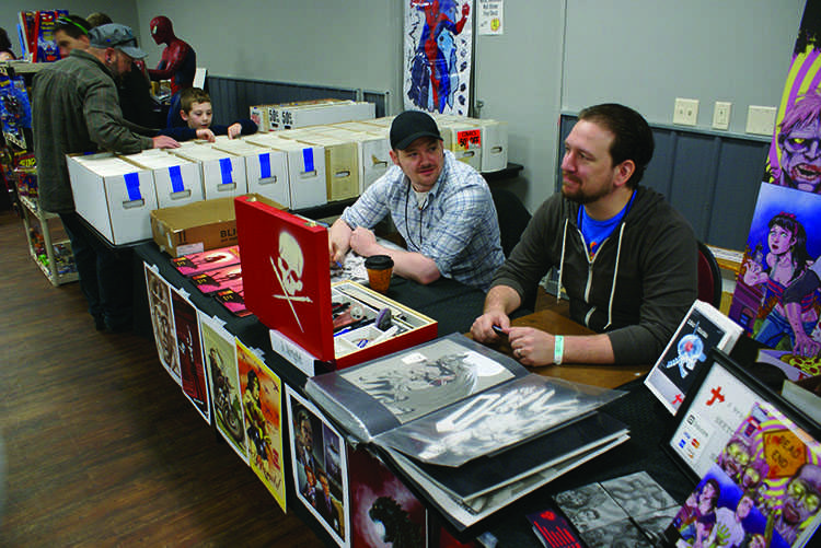 Andy Taylor (left) and Jason Wright attend to their vendor spot at the Comic Con Saturday at the Action City Family Fun Center.