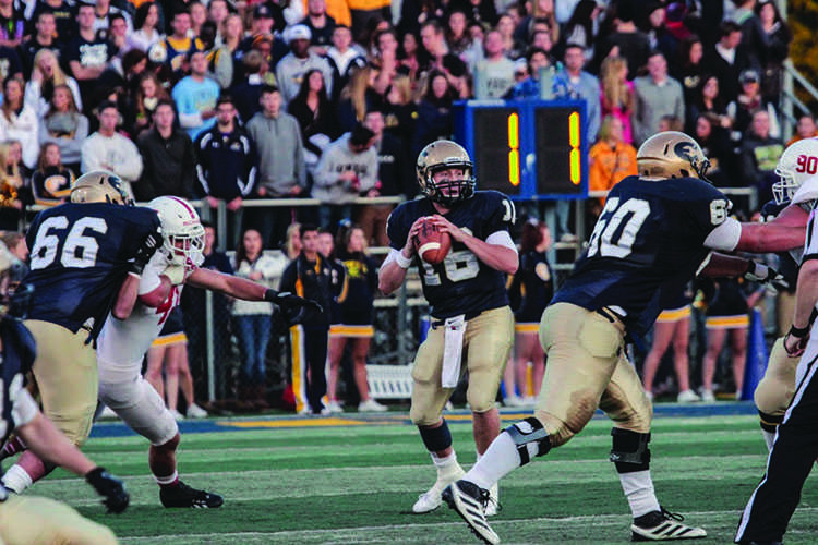 Senior quarterback Mark Munger looks for a pass downfield against St. Johns Saturday night at Carson Park.