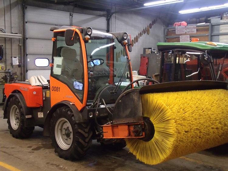 Holder Tractors are the main way facilities management remove snow from sidewalks, the footbridge, and the hill. When not in use, they are stowed away in the facilities management building. - Photo by Sam Martinez