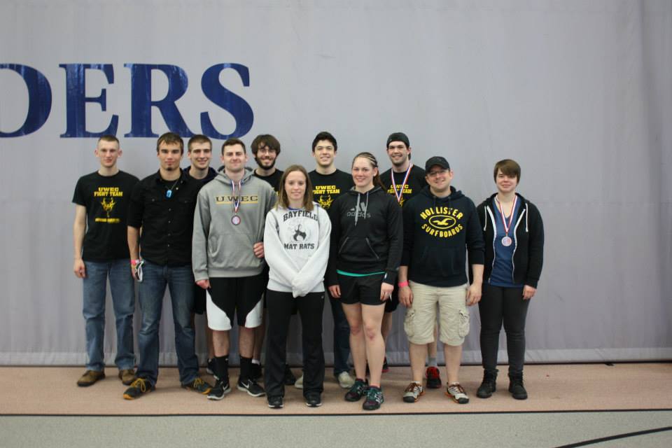 The University of Wisconsin Eau Claire Mixed Martial Arts Club poses for a picture in after finishing competition at the 2013-2014 Hudson Grappling Tournament. Hannah Herzfeld (left) earned second place at the competition.