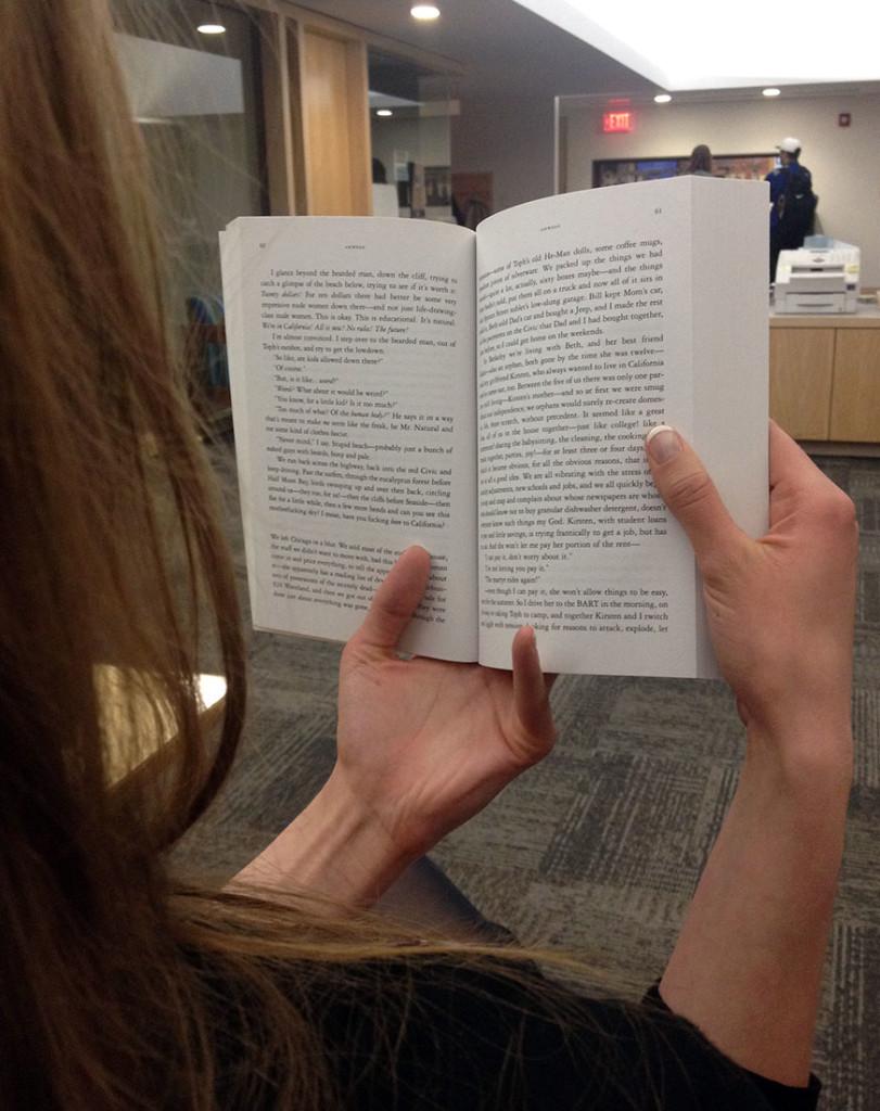 Lauren French ignores her coworkers and reads a book in The Spectator office.