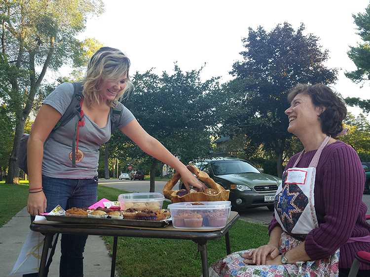 Homeowner Jennifer Eddy and Junior Sarah Fulton share a laugh over muffins. 