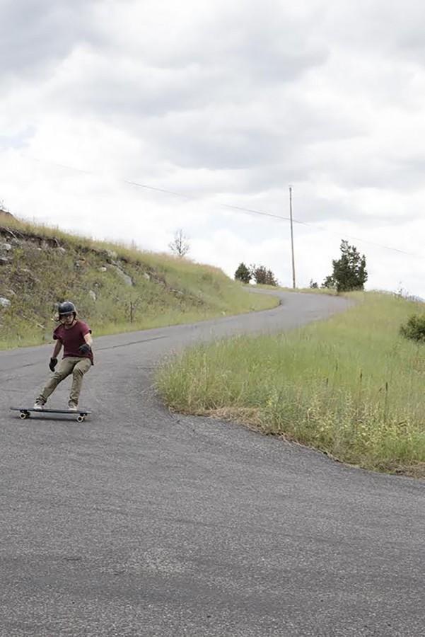 While in Livingston, Montana for a summer of skating, student Ben Cole does a powerslide into a left-hand hairpin turn down a mountain.