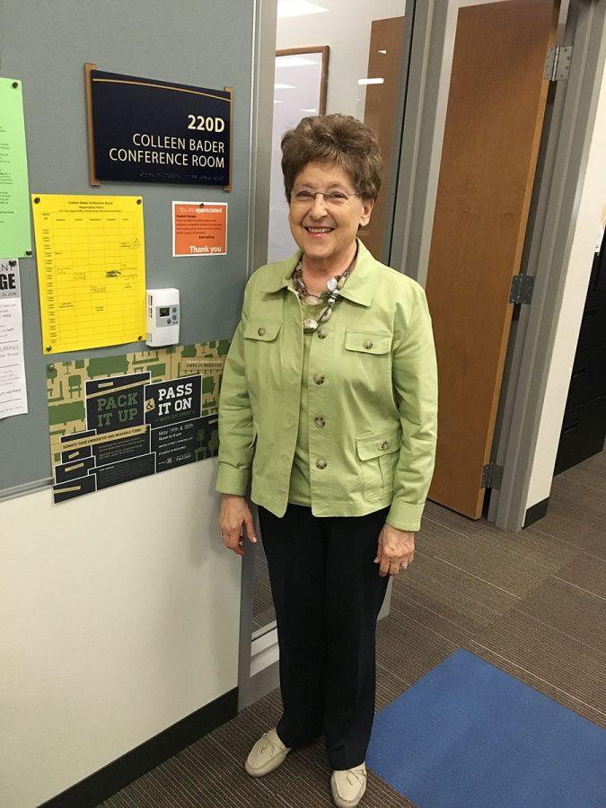 Colleen Bader stands in front of the conference room in the Student Senate named after her.

