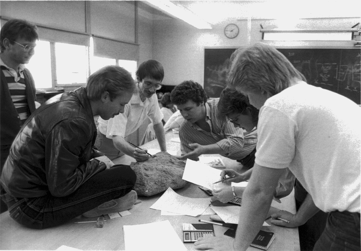 In a 1990s geology class, students studied the characteristics of a large rock with Professor Kent Syverson.