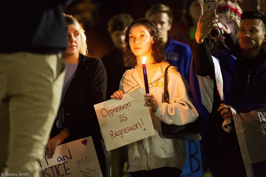 Senior social work student Diosa Marie Withington listens to speeches before the peaceful protest Thursday evening. Withington participated in both events and said they served different purposes. 