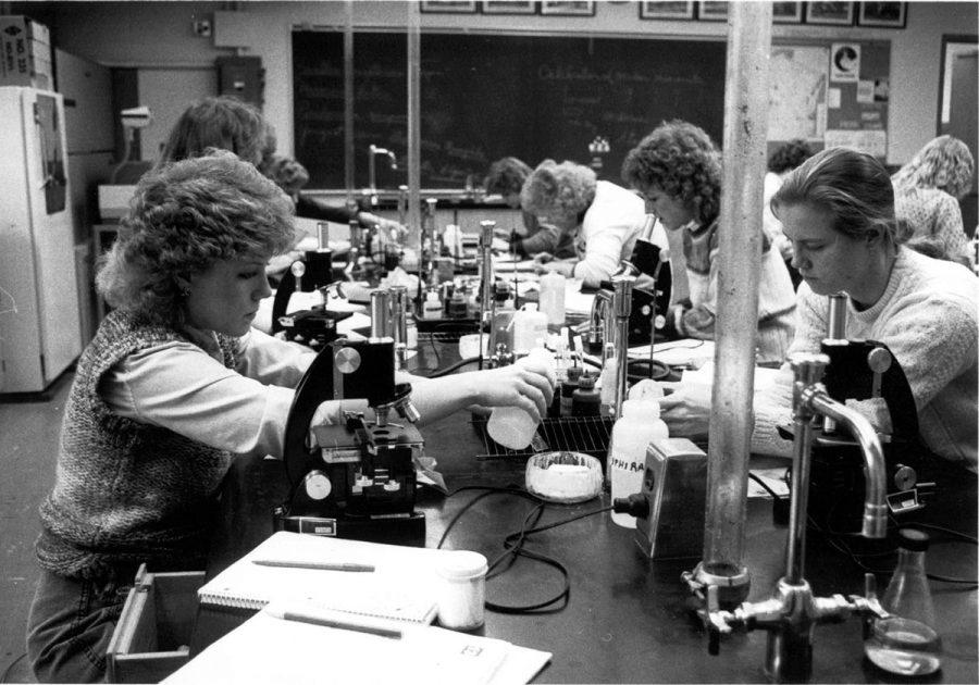 This 1980 photograph shows students in Biology class performing an experiment.