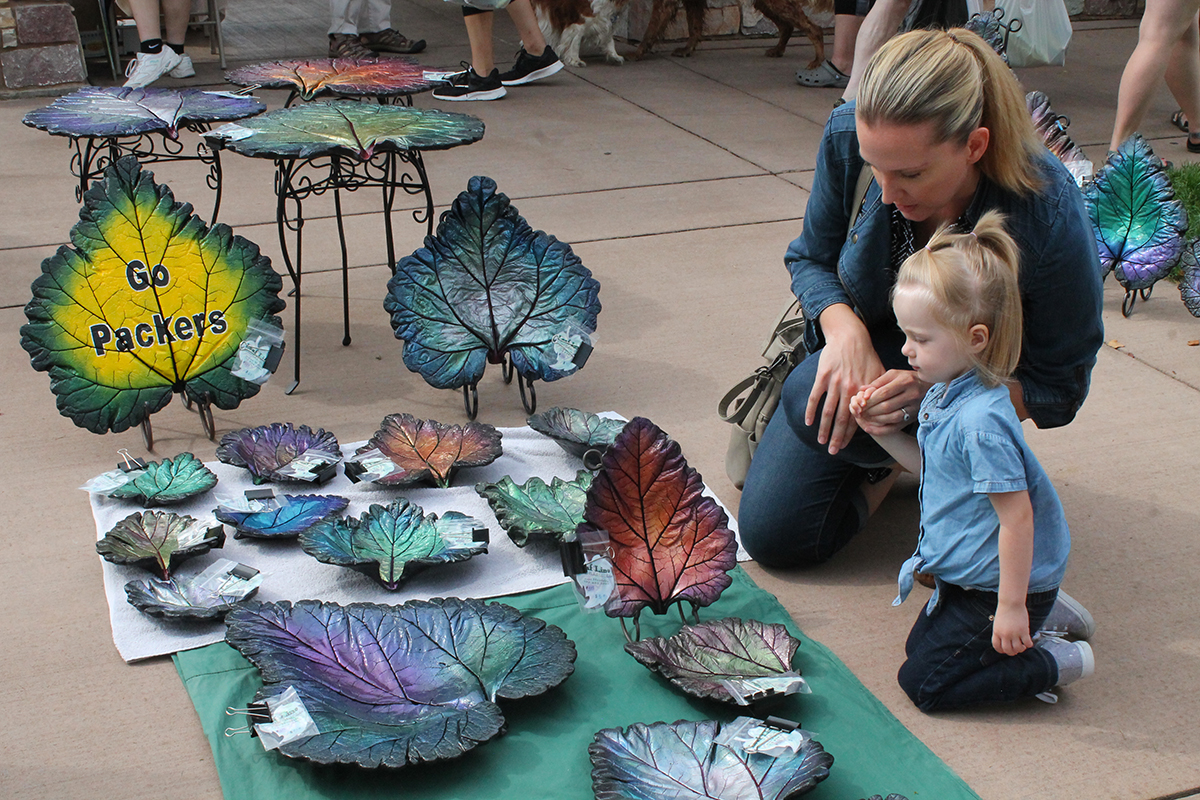 Mother+and+daughter+glance+over+the+art+displays+at+the+Eau+Claire+Farmers+Market.+