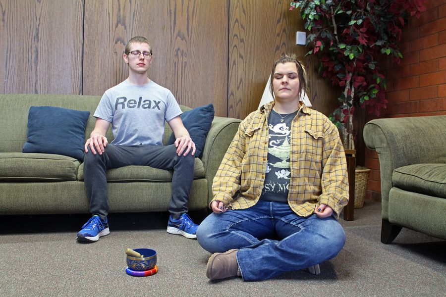 Katie Christian (right), club president, and Kyle Hagen (left), vice president, demonstrate their different approaches to meditation. The Organization for Meditation meets from 11 a.m. to noon on Tuesdays throughout spring semester. 