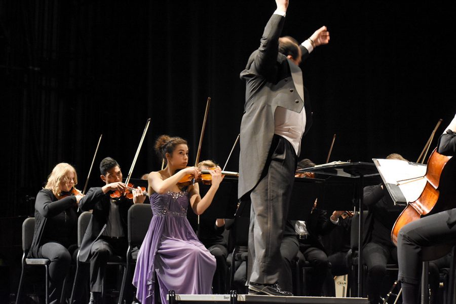 Winner of string division, Anne Schreiber, looks on to student conductor Carlos Rojo at Sunday’s orchestra concert.

