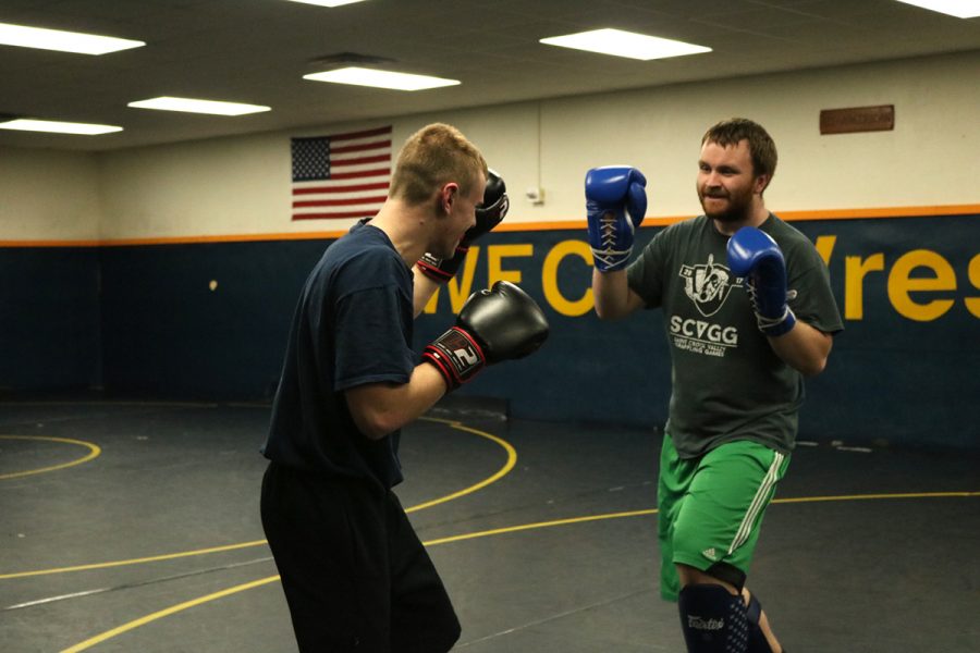 Levi Smith and Tanner Semb, members of the Mixed Martial Arts Club, practice their fighting moves on each other.
