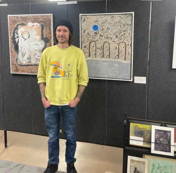 Jesse Hay stands beside his favorite painting on display at The 1106.
